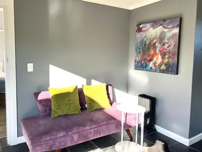 a living room with a purple couch with yellow pillows at Spacious Stays Apartment in Paarl