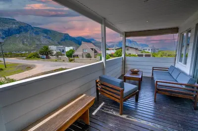 a porch with benches and a view of the mountains at Stony Point Beach House in Clareport