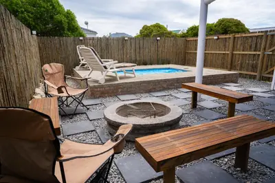 a patio with a table and chairs and a pool at Stony Point Beach House in Clareport