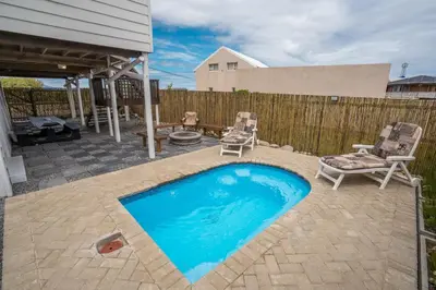 a backyard with a swimming pool and two chairs at Stony Point Beach House in Clareport
