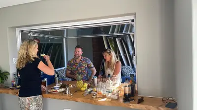 a group of people standing around a table with wine bottles at Boardrooms Kite Accommodation in Cape Town