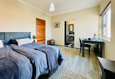 a bedroom with a bed and a desk at Boardrooms Kite Accommodation in Cape Town