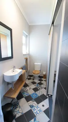 a bathroom with a sink and a toilet at Boardrooms Kite Accommodation in Cape Town
