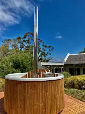 a wooden tub with a fountain in front of a house at Penhill Farm Peppertree Cottage in Nuy