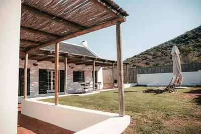 a view of a house with a patio and an umbrella at Penhill Farm Peppertree Cottage in Nuy