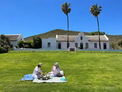 two people sitting on a blanket in the grass at Penhill Farm Peppertree Cottage in Nuy