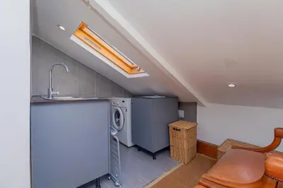 a kitchen with a sink and a washer and dryer at Casa Lucia in Cape Town