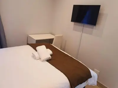 a bedroom with a bed with two towels on it at ELMED GUEST HOUSE in Cape Town