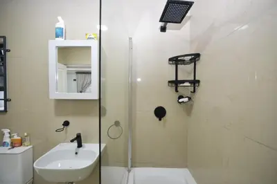 a bathroom with a shower and a sink and a toilet at ELMED GUEST HOUSE in Cape Town
