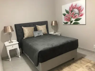 a bedroom with a bed with two night stands and two lamps at MLMK Property 17 in Cape Town
