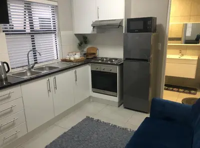 a kitchen with a stainless steel refrigerator and a sink at MLMK Property Studio17 in Cape Town
