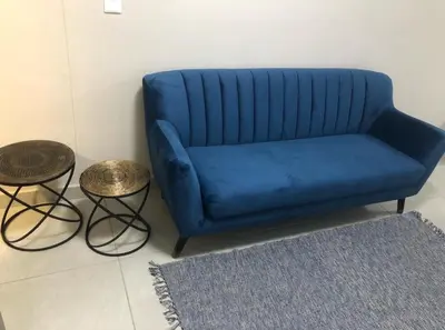 a blue couch in a living room with two tables at MLMK Property Studio17 in Cape Town