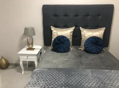 a bedroom with a large bed with blue pillows at MLMK Property Studio17 in Cape Town