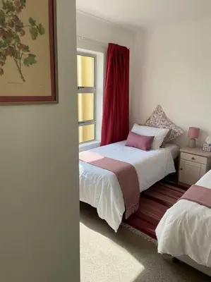 a bedroom with two beds and a window at Sunset Paradise in Cape Town