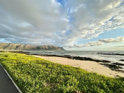 a beach with a view of the ocean and mountains at Sunset Paradise in Cape Town
