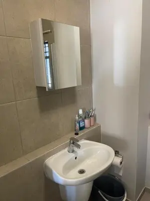 a bathroom with a white sink and a mirror at Eden Heights in Cape Town