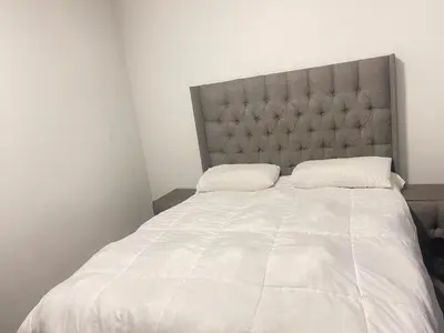 a bedroom with a large white bed with a headboard at Eden Heights in Cape Town