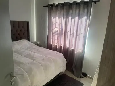 a bedroom with a bed and a curtain at Eden Heights in Cape Town
