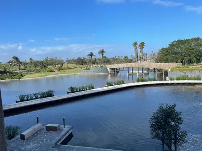 a large body of water with a bridge and palm trees at Bridgewater one luxury Apartment in Cape Town