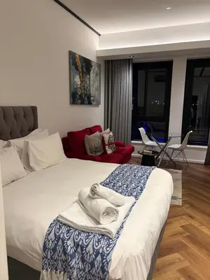 a bedroom with a bed and a living room at Bridgewater one luxury Apartment in Cape Town
