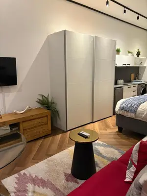 a living room with a large white cabinet and a table at Bridgewater one luxury Apartment in Cape Town
