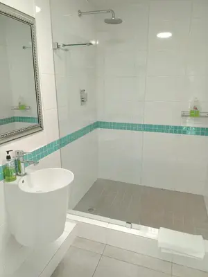 a white bathroom with a shower and a sink at Pecan Tree Forest Studio A in Stellenbosch