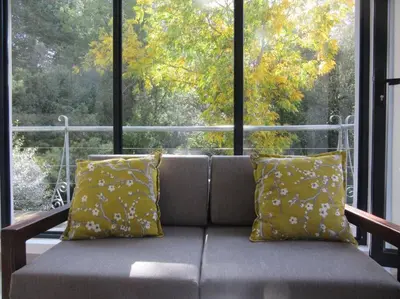 a couch sitting in front of a large window at Pecan Tree Forest Studio A in Stellenbosch