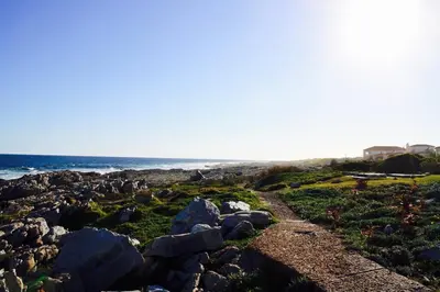 a rocky beach with the ocean in the background at Easy Going Hermanus With An Ocean View in Hermanus