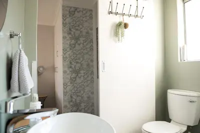 a bathroom with a white toilet and a door at Easy Going Hermanus With An Ocean View in Hermanus