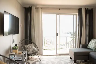 a living room with a couch and a large window at Easy Going Hermanus With An Ocean View in Hermanus