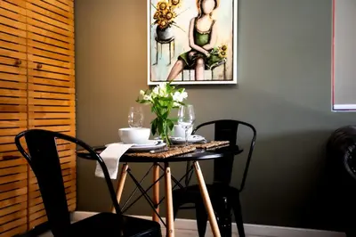 a dining room table with chairs and flowers on it at Oak on Main in Hermanus