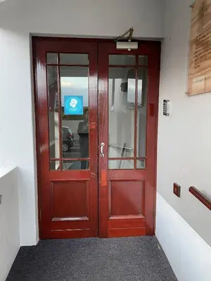 a red door in a building with a sign on it at Oak on Main in Hermanus