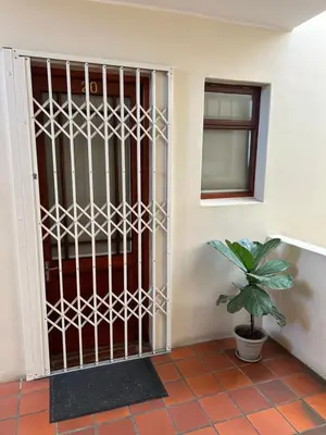 a gate in a room with a potted plant at Oak on Main in Hermanus