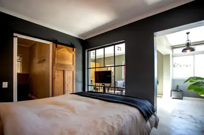 a bedroom with black walls and a large bed at Oak on Main in Hermanus