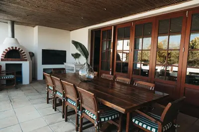 a dining room with a wooden table and chairs at Mitre's Edge Pool House in Klapmuts