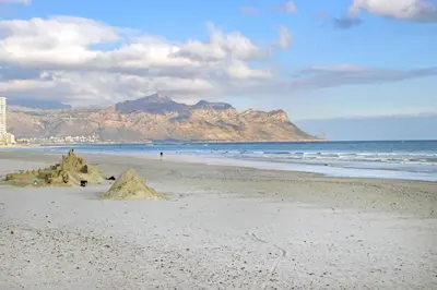 a couple of sand castles on a beach with a mountain at Jacquelena Hof 9 in Strand