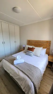 a bedroom with a large white bed with two pillows at Villa Nordica - 2 bedroom self-catering apartment in Cape Town