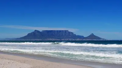 a view of the beach with a mountain in the background at Villa Nordica - 2 bedroom self-catering apartment in Cape Town