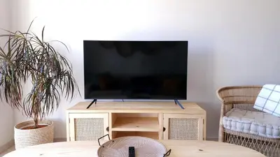 a flat screen tv sitting on top of a wooden stand at Villa Nordica - 2 bedroom self-catering apartment in Cape Town