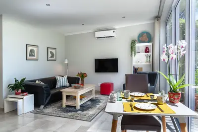 a living room with a table and a couch at Tortelduif Cottage in Stellenbosch