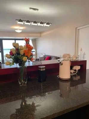 a kitchen with a vase of flowers on a counter at Beautiful Ocean View Apartment in Cape Town