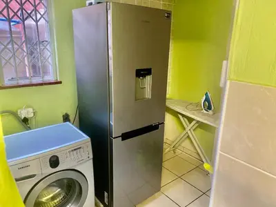 a kitchen with a refrigerator and a washing machine at Beautiful apartment in century city in Cape Town
