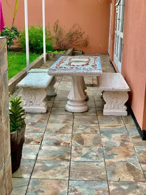 a patio with a table and benches on a porch at Beautiful apartment in century city in Cape Town