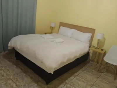a bedroom with a bed with two towels on it at Jacmo Guest house in Cape Town