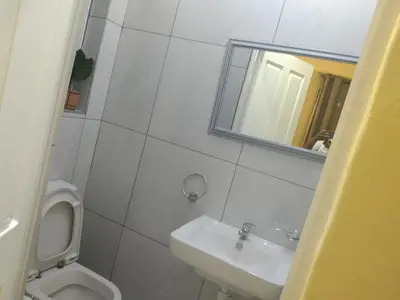 a bathroom with a toilet and a sink and a mirror at Jacmo Guest house in Cape Town