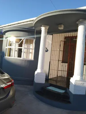 a house with white columns and a door with a gate at Jacmo Guest house in Cape Town