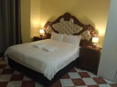 a bedroom with a large bed with two lamps on tables at Jacmo Guest house in Cape Town