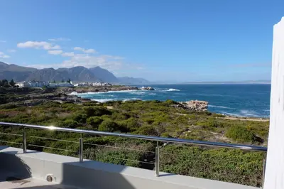 a view of the ocean from the balcony of a house at 11 WESTCLIFF RENTALS in Hermanus