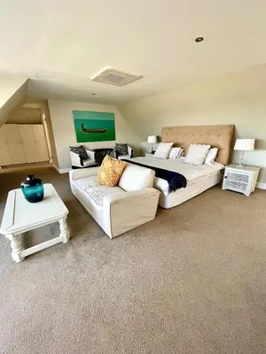 a large bedroom with a bed and a couch at 11 WESTCLIFF RENTALS in Hermanus