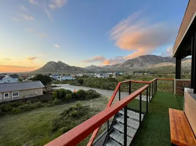 a balcony of a house with a view of the mountains at Escape to Pringle in Pringle Bay